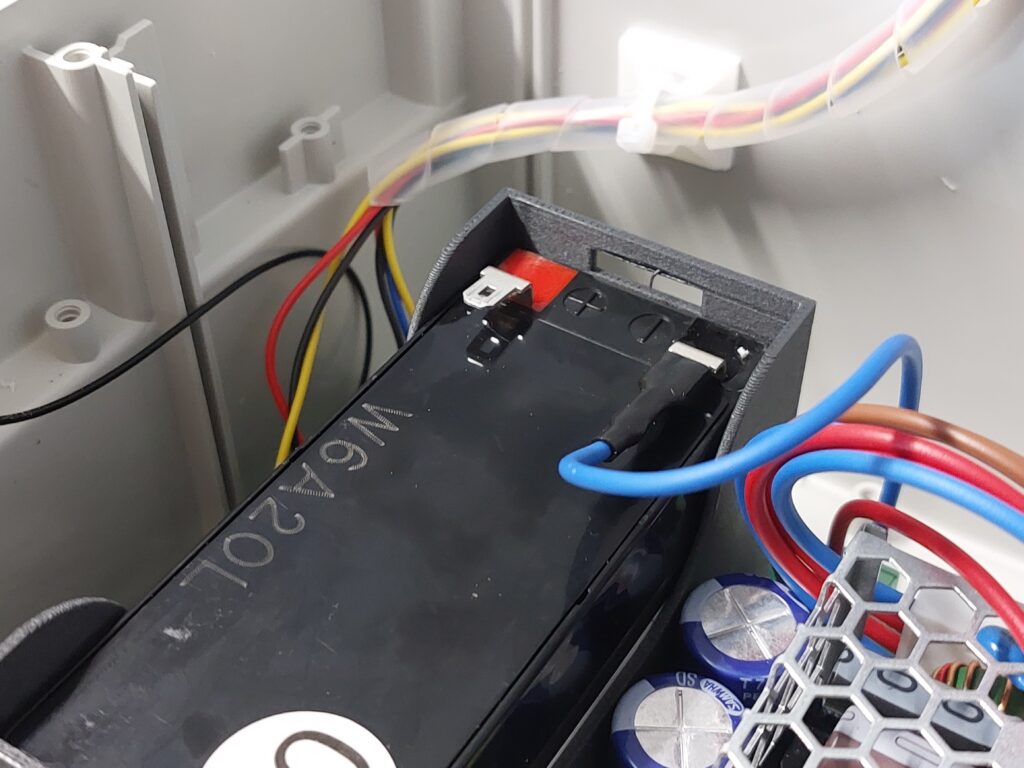 Another shot of the battery during the assembly process. You can see the removed covers and the blue wire already connected to one of the terminals, while the connector marked in red is still empty.