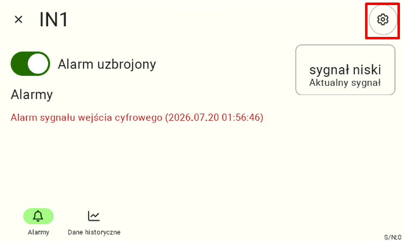 Widok szczegółów uzbrojonego wejścia cyfrowego "IN1", na którym aktualnie trwa stan alarmowy (sygnalizowany czerwonym komunikatem). Aby wejść w zaawansowaną konfigurację parametrów wyzwalacza tego alarmu, użytkownik musi kliknąć ikonę koła zębatego w prawym górnym rogu ekranu, która na instrukcji została obramowana czerwoną ramką.