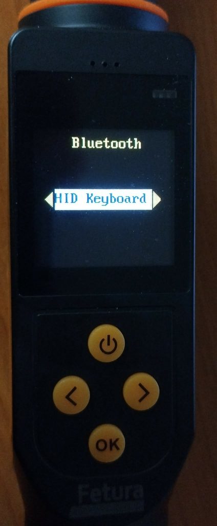 Obraz przedstawia ekran skanera 1 ze zbliżeniem na ekran i przyciski. Widok wewnątrz ustawień bluetooth, zaznaczona jest opcja HID Keyboard.